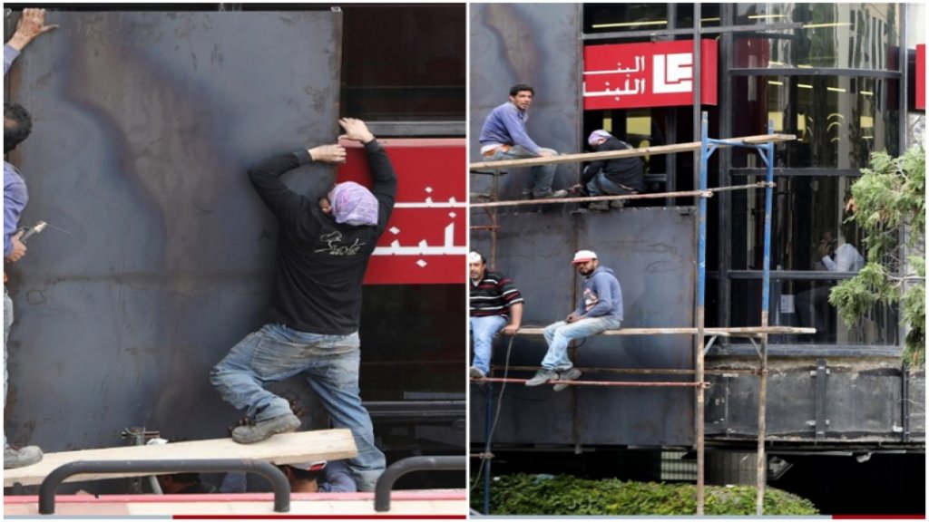 بالصور/ مصرف في لبنان يعمد إلى تركيب واجهات حديدية لحمايته من الحرق والتكسير الذي يطال المصارف منذ أيام!