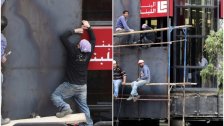بالصور/ مصرف في لبنان يعمد إلى تركيب واجهات حديدية لحمايته من الحرق والتكسير الذي يطال المصارف منذ أيام!