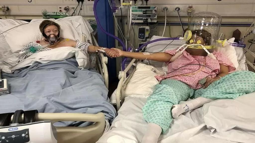 لحظة الوداع.. صورة لأم تمسك يد ابنتها في مستشفى في بريطانيا أثناء علاجهما من كورونا، بعد 24 ساعة توفيت الأم