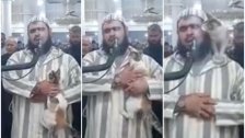 بالفيديو/ اقتحام لطيف.. قطة تعتلي كتف إمام مسجد في الجزائر أثناء تأدية الصلاة